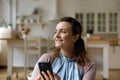 Smiling thoughtful young woman holding mobile phone Royalty Free Stock Photo