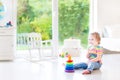 Smiling toddler girl playing with a pyramid toy