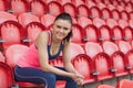 Smiling toned woman sitting on chair in the stadium