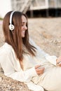 Smiling totally happy woman lying on a sea sand and listening music