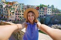 Smiling tourist girl taking selfie photo on sunny day in Riomaggiore village, Cinque Terre, Italy Royalty Free Stock Photo