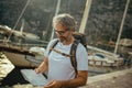 Tourist mature man standing with map and backpack near the sea Royalty Free Stock Photo