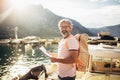 Tourist mature man standing with map and backpack near the sea Royalty Free Stock Photo