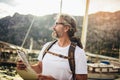 Tourist mature man standing with map and backpack near the sea Royalty Free Stock Photo