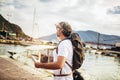 Tourist mature man standing with map and backpack near the sea Royalty Free Stock Photo