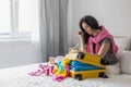 Smiling tourist woman packing suitcase to vacation writing paper list getting ready to travel trip Royalty Free Stock Photo