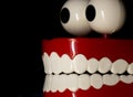 A smiling toy prosthesis, with white teeth and large eyes isolated against a black background. Royalty Free Stock Photo