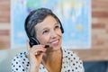 Smiling travel agent sitting at her desk Royalty Free Stock Photo