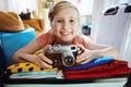 Smiling traveller girl with retro film camera packing suitcase Royalty Free Stock Photo