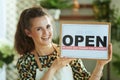 Smiling trendy business owner woman in apron showing open sign Royalty Free Stock Photo