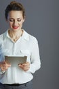 smiling trendy business woman against gray background