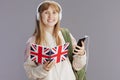 smiling trendy school girl in beige tracksuit with backpack