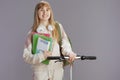 smiling trendy teenage girl in beige tracksuit with workbooks Royalty Free Stock Photo