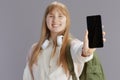 smiling trendy teenage girl showing smartphone blank screen