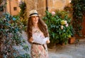 Smiling trendy traveller woman in Pienza, Italy sightseeing