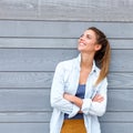 Smiling trendy woman standing with arms crossed