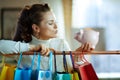 Woman near shopping bags with piggy bank blowing air kiss Royalty Free Stock Photo