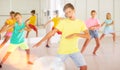 Tween boy training movements of vigorous dance in choreographical studio