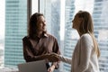 Smiling two business women shaking hands making agreement. Royalty Free Stock Photo