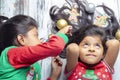 Smiling sisters decorating their hair with Christmas decorations