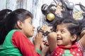 Smiling sisters decorating their hair with Christmas decorations