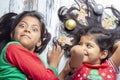 Smiling sisters decorating their hair with Christmas decorations