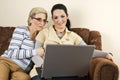 Smiling two women with laptop home Royalty Free Stock Photo