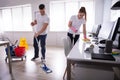 Smiling Two Young Janitor Cleaning The Office