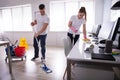 Smiling Two Young Janitor Cleaning The Office Royalty Free Stock Photo