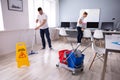 Smiling Two Young Janitor Cleaning The Office Royalty Free Stock Photo