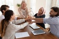 United business people join hands in stack pile at meeting