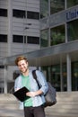 Smiling university student standing outside with notepad Royalty Free Stock Photo