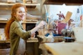 Smiling unusual pottery master choosing tools for work