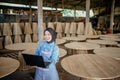 Smiling veiled Asian woman looking at camera while using laptop computer Royalty Free Stock Photo