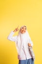 smiling veiled girl in school uniform with finger pointing up