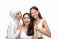 Smiling a veiled girl and two asian young girl stand next to each other