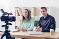Smiling video bloggers recording vlog at table Royalty Free Stock Photo
