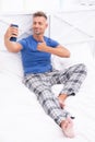 smiling video call man with phone wear pajama. video call man with phone in bed.