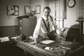 Smiling vintage businessman sitting on desk Royalty Free Stock Photo