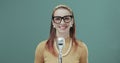 Smiling vintage style woman standing in front of a microphone