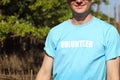 Smiling volunteer man in blue t-shirt standing at mangrove forest, after planting sapling tree in deep mud for increasing mangrove Royalty Free Stock Photo