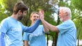 Smiling volunteers giving high five, cooperation gesture, environmental project