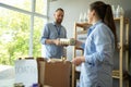 Smiling volunteers packing food and drinks in boxes at distribution or refugee assistance center. Charity and donation Royalty Free Stock Photo