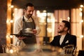 Smiling Waiter Bringing Coffee to Guest in Restaurant Royalty Free Stock Photo