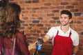 Smiling waiter handing a pin terminal