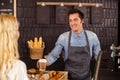 Smiling waiter serving a coffee to a customer Royalty Free Stock Photo