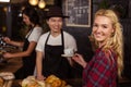 Smiling waiter serving a coffee to a customer Royalty Free Stock Photo