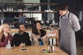 Smiling waiter taking payment from client Royalty Free Stock Photo