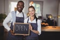 Smiling waiter and waitress showing chalkboard with open sign Royalty Free Stock Photo