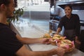 Smiling waitress giving baskets with food to coworker in cafe Royalty Free Stock Photo